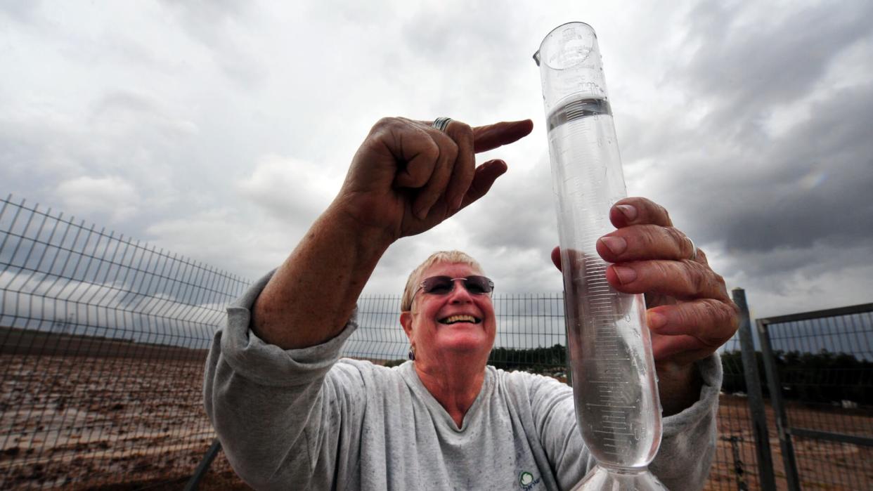 Negba, Israel - October 30, 2009: Smiling and happy Meteorologist measures water level in a rain gauges.