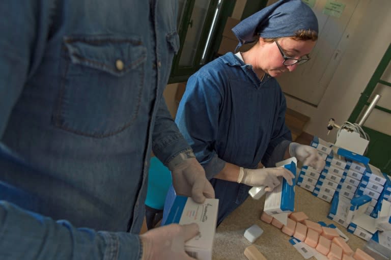 Sister Elie Marie (R) and a non-religious employee package soap at the Saint-Vincent abbey in Chantelle