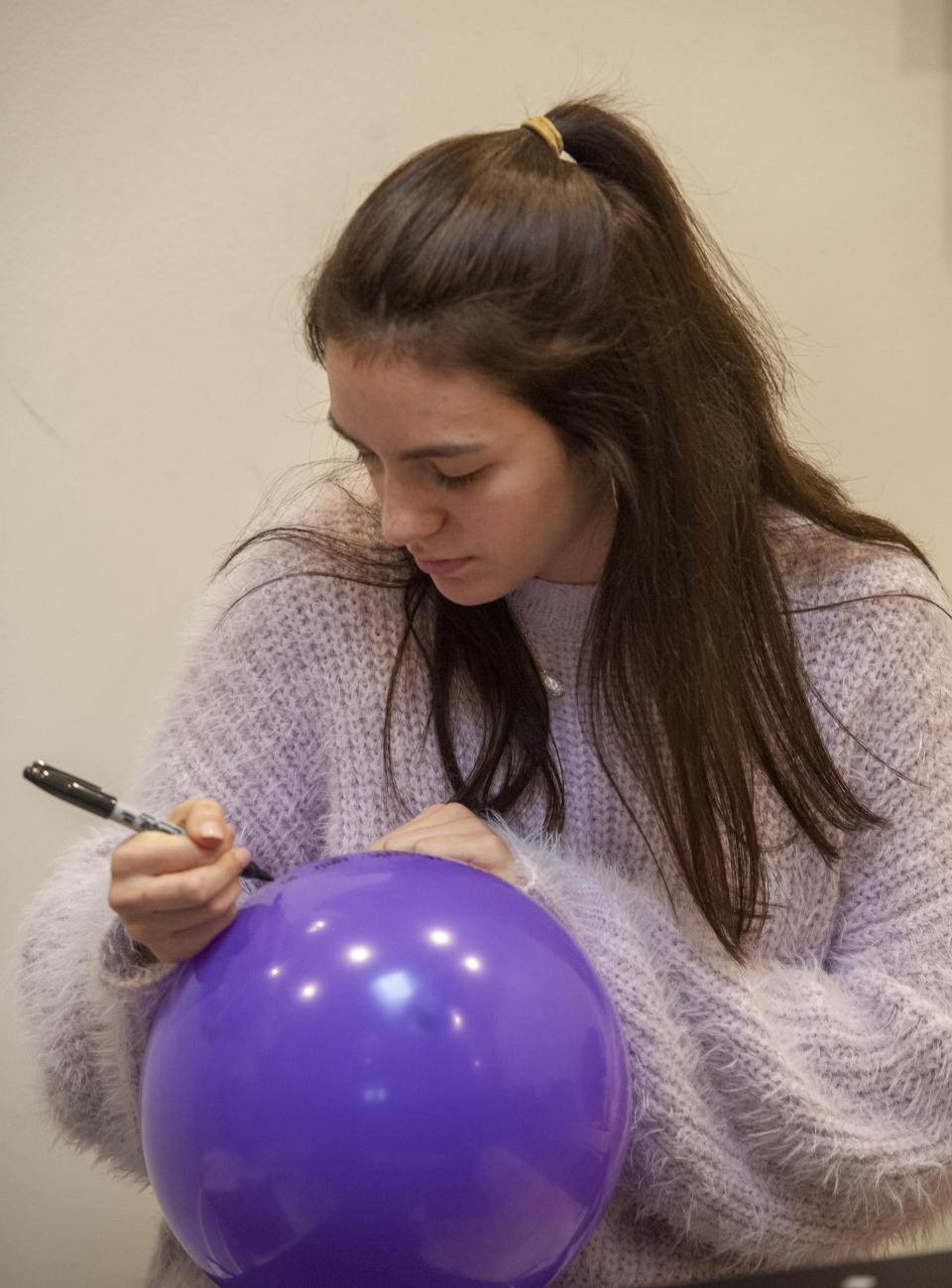 Friend and classmate of Walker Vincent Grace Morgan write a note to him on a balloon during a16th birthday party for him at Leslie Jacob's home on Sunday, December 29, 2019 in Lafayette, La. Walker Vincent was one of the victims in the plane crash on Saturday. Family and friends threw him a birthday party where they released LSU balloons and marked gifts with their favorite memories of Walker for his father. (Brad Kemp/The Advocate via AP)