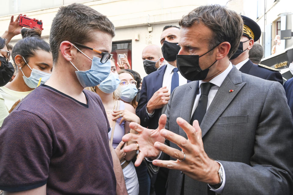 French President Emmanuel Macron talks to a resident Tuesday June 8, 2021 in Valence, southeastern France. French President Emmanuel Macron was slapped Tuesday in the face by a man during a visit to a small town of of Tain-l'Hermitage in southeastern France, an incident that prompted a wide show of support for French politicians from all sides. (Philippe Desmazes, Pool via AP)