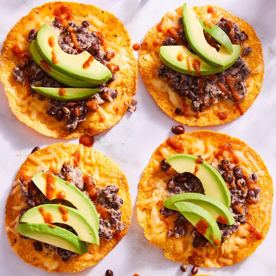 tostadas topped with black beans, cheese, and avocado slices