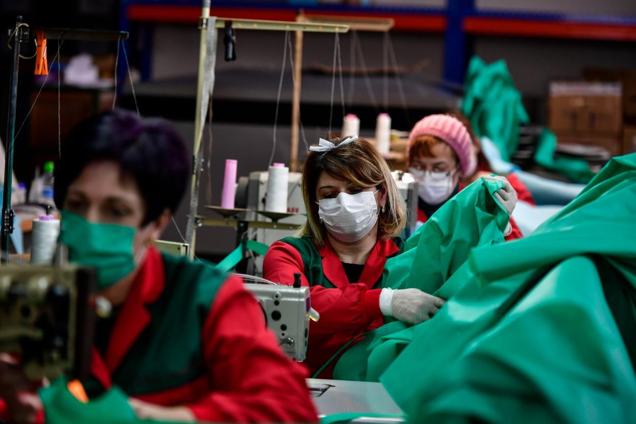 Volunteer workers in a clothing factory manufacturing firefighting gear, make hospital gowns for medical staff to protect them from the coronavirus, in Arnedo, northern Spain, on Monday, March 30, 2020.