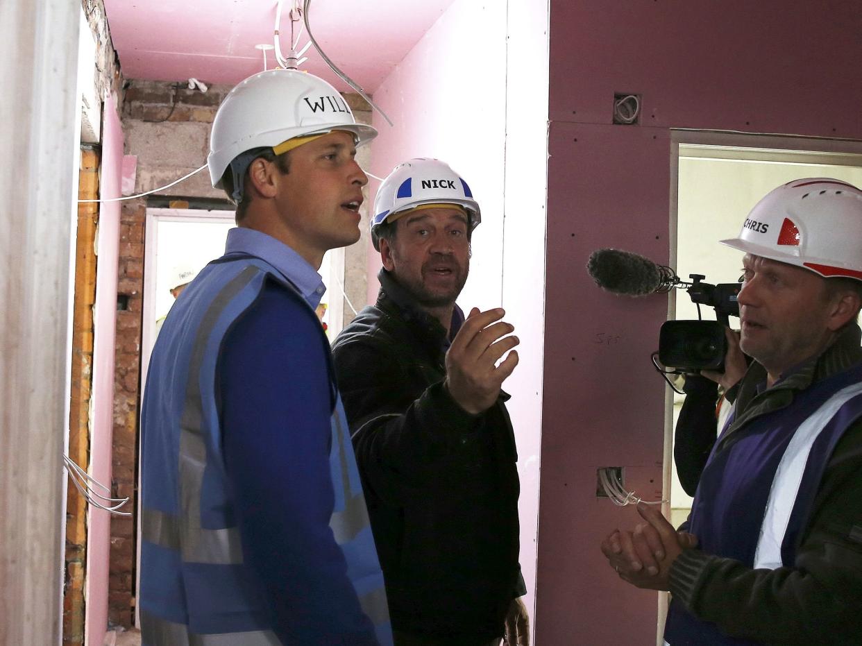  Prince William speaks with presenter Nick Knowles as he helps to renovate homes as part of the BBC television DIY SOS series