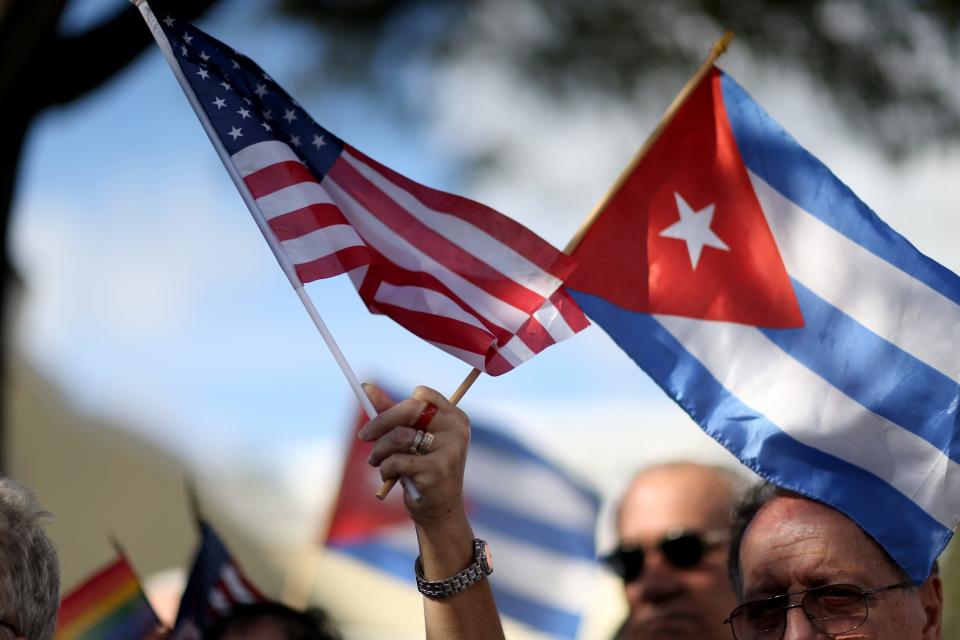 A protester holds American and Cuban flags during a demonstration at Jose Marti park on December 20, 2014, in Miami after President Obama announced his decision to normalize relations with Cuba.