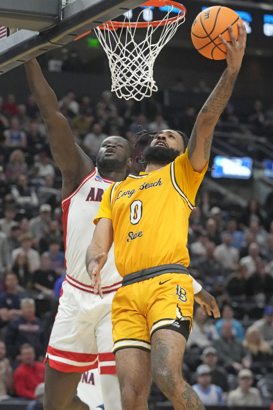 Long Beach State guard Marcus Tsohonis (0) goes to the basket as Arizona center Oumar Ballo, rear, defends during the first half of a first-round college basketball game in the NCAA Tournament in Salt Lake City, Thursday, March 21, 2024. (AP Photo/Rick Bowmer)