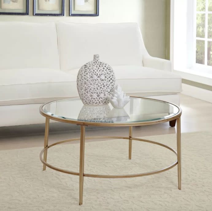 <a href="https://www.wayfair.com/furniture/pdp/birch-lane-nash-round-coffee-table-bl11935.html" target="_blank">The simple lines of this coffee table</a> are both airy and luxe, giving your space an open, clean feel.