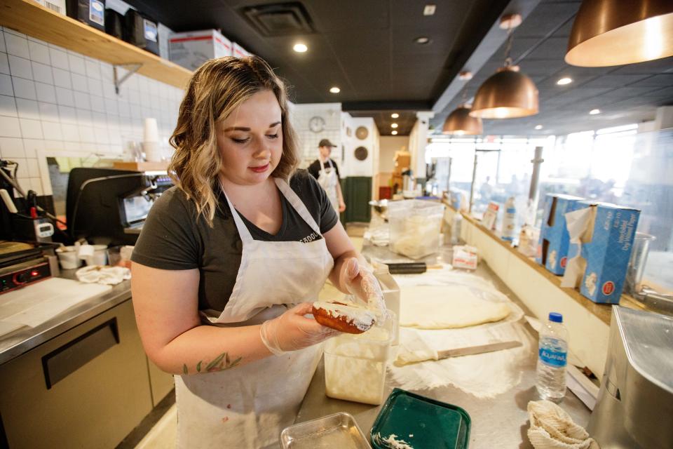 Crystal Leduc, the new co-owner of SōDOUGH Baking Co., frost a donut Thursday, Feb. 3, 2022.