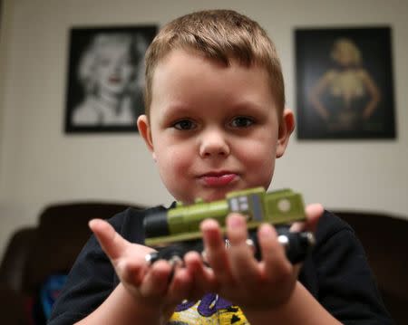 Joshua Sekerak plays with his train at his home in Leetonia, Ohio, United States on May 21, 2016. REUTERS/Aaron Josefczyk