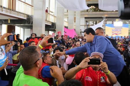 Venezuela's President Nicolas Maduro (R) greets supporters as he arrives for an event in Caracas, Venezuela July 20, 2017. Miraflores Palace/Handout via REUTERS