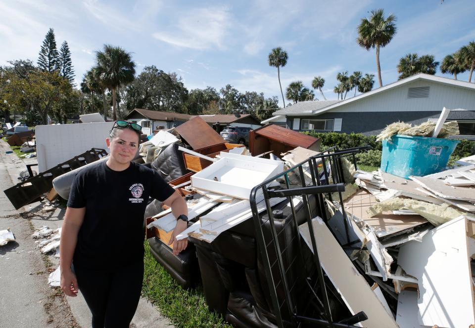 Volusia County Firefighter Katie Dees stands with most of the contents of her Port Orange home after much of it was destroyed by flooding from Tropical Storm Ian, Tuesday, Oct. 11, 2022.