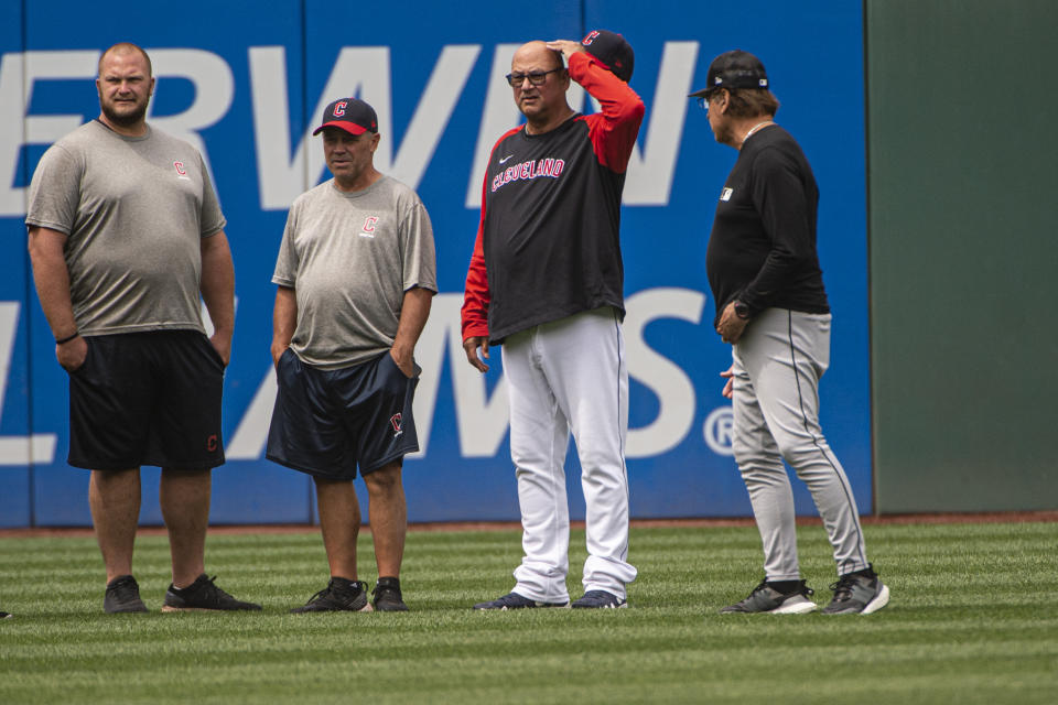 Unidentified members of the Cleveland Guardians grounds crew wait with Guardians manager Terry Francona, second from right, and Chicago White Sox manager Tony LaRussa, right, for umpires as they inspect the condition of Progressive Field before a baseball game in Cleveland, Sunday, Aug. 21, 2022. (AP Photo/Phil Long)