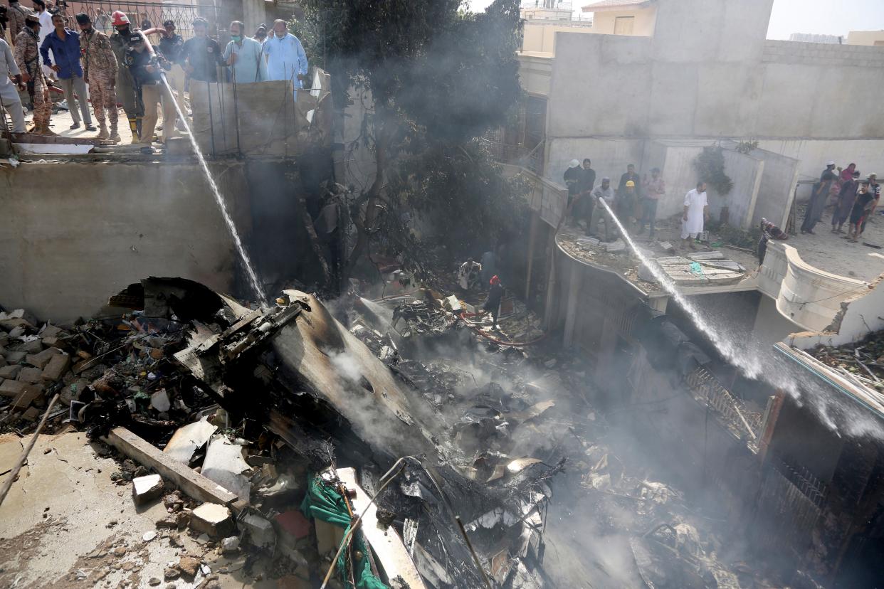 Fire brigade staff try to put out fire caused by plane crash in Karachi, Pakistan, Friday, May 22, 2020. An aviation official says a passenger plane belonging to state-run Pakistan International Airlines carrying more than 100 passengers and crew has crashed near the southern port city of Karachi. There were no immediate reports on the number of casualties. (AP Photo/Fareed Khan