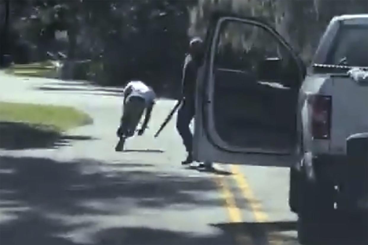 This image from video posted on Twitter Tuesday, May 5, 2020, purports to show Ahmaud Arbery stumbling and falling to the ground after being shot as Travis McMichael stands by holding a shotgun in a neighborhood outside Brunswick, Ga., on Feb. 23, 2020. 