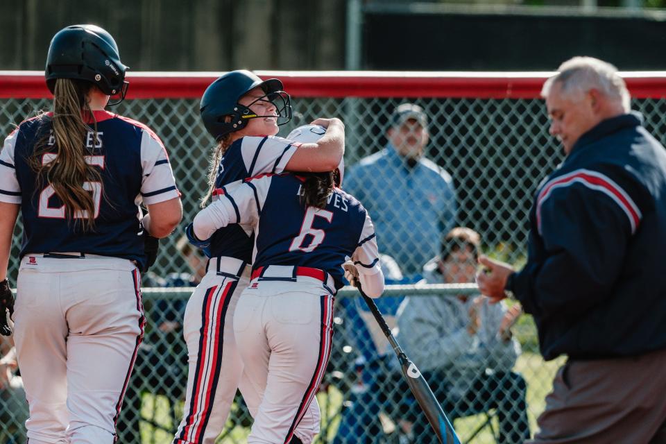 Indian Valley's Natlalie Musser is embraced by a teammate after crossing home plate during a DII Sectional Final game against Dover, Friday, May 10 in Dover.