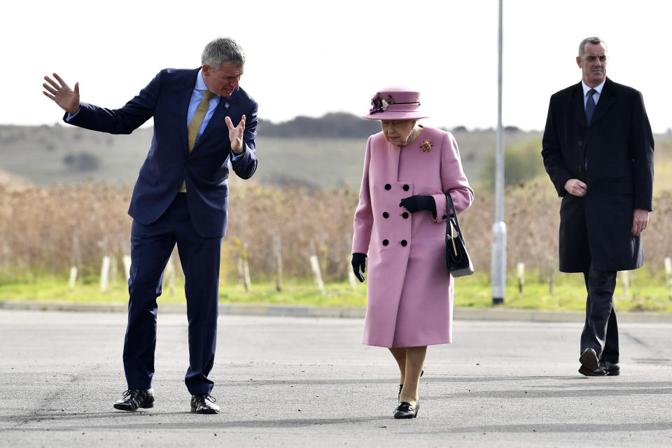 Britain's Queen Elizabeth II is greeted by Chief Executive Gary Aitkenhead prior to a visit to the Defence Science and Technology Laboratory (DSTL) at Porton Down, England, Thursday Oct. 15, 2020, to view the Energetics Enclosure and display of weaponry and tactics used in counter intelligence. (Ben Stansall/Pool via AP)