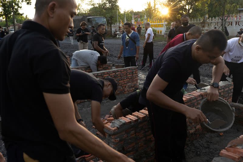 Army personnel work on the funeral pyre preparations for the cremation ceremony of the victims of a mass shooting in the town of Uthai Sawan