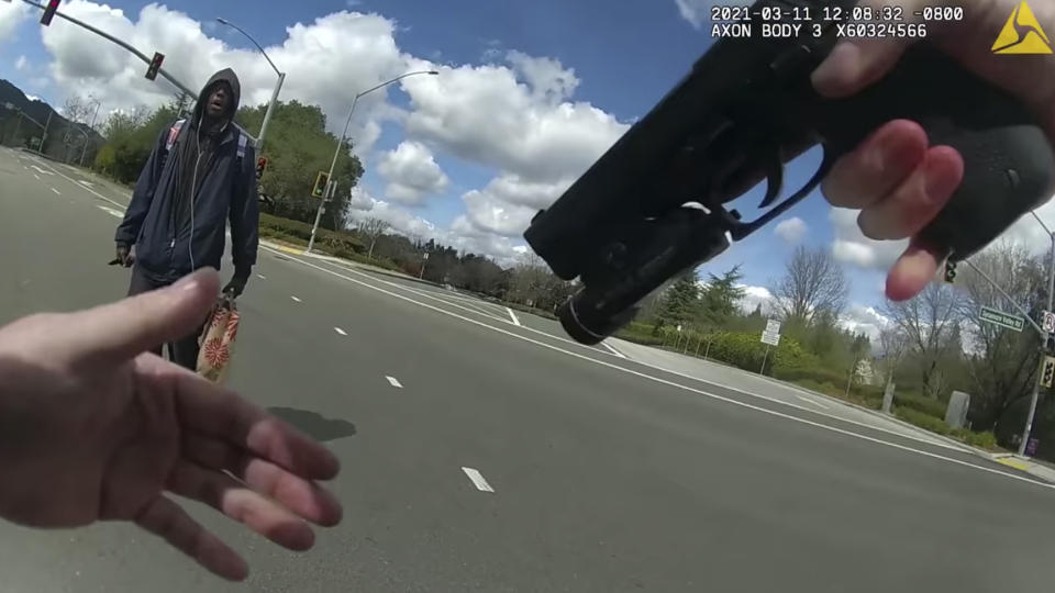 This image from body-worn camera video provided by the Contra Costa County Sheriff’s Office shows Tyrell Wilson, left, holding a knife in his right hand, in front of Officer Andrew Hall in the middle of an intersection, March 11, 2021, in Danville, Calif. Graphic body camera footage released April 21, 2021, shows Hall call out to Wilson, accusing him of jaywalking and throwing rocks, and then shoots him in the middle of the intersection within seconds of asking him to drop his knife. This and another fatal shooting by Hall have cast a spotlight on what criminal justice activists are calling a case of delayed justice and its deadly consequences. (Contra Costa Sheriff via AP)