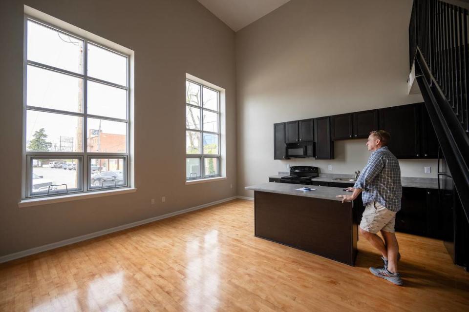 Developer Kelley Hrabe looks out the windows of an apartment in a converted racquetball court in Y Lofts.The two-story loft-style unit features a bedroom and bathroom on each floor. The floors, original to the racquetball court, were refinished for the apartment.