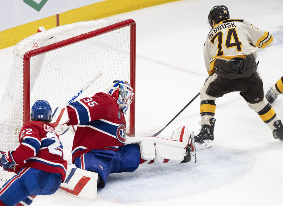 Boston Bruins' Jake DeBrusk (74) scores against Montreal Canadiens goaltender Sam Montembeault (35) during overtime NHL hockey action in Montreal, Thursday, March 14, 2024. (Christinne Muschi/The Canadian Press via AP)