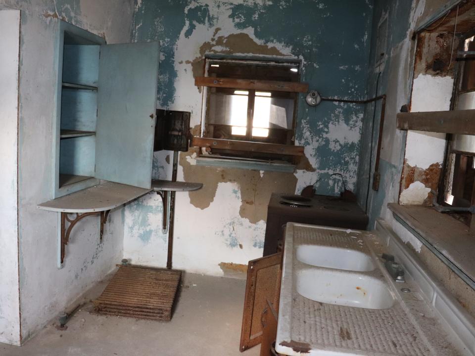 kitchen in the home on ellis island with crumbling paint and two sinks