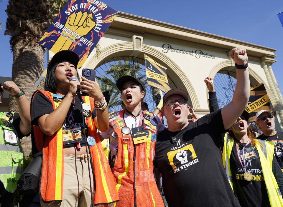 ARCHIVO - Los capitanes de SAG-AFTRA Iris Liu, izquierda, y Miki Yamashita, centro, el principal negociador de SAG-AFTRA Duncan Crabtree-Ireland en una manifestación de actores en huelga fuera del estudio de Paramount Pictures el 3 de noviembre de 2023, en Los Angeles. El sindicato SAG-AFTRA anunció que comenzará una huelga el 26 de junio por preocupaciones ante el uso sin protecciones de inteligencia artificial en la industria de los videojuegos. (Foto AP/Chris Pizzello, archivo)