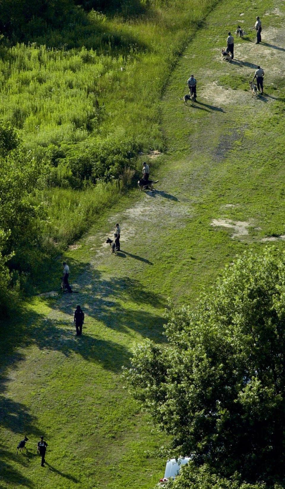 Police with search dogs trained to find buried remains comb the Dan Ryan Woods at 90th Street and Damen Ave., in Chicago on July 10, 2001, in the search for sisters Tionda, 10, and Diamond Bradley, 3, who went missing July 6.