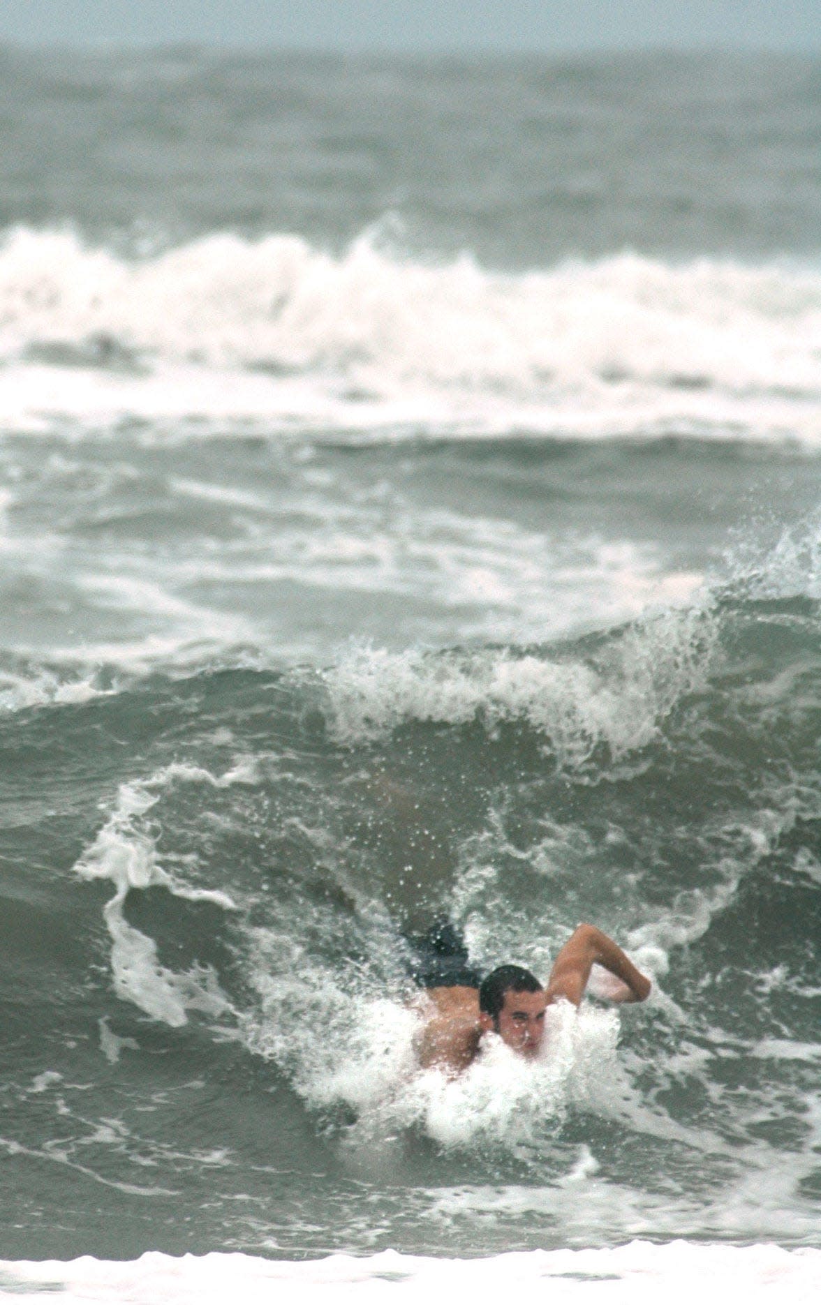 A swimmer body surfs the waves churned up by Tropical Storm Ophelia at Wrightsville Beach in 2005.