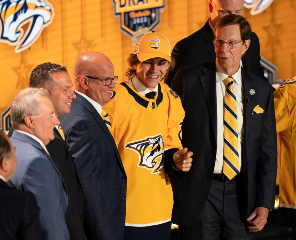 First round pick Tanner Molendyk poses with outgoing Nashville Predators General Manager David Poile, right, and the front office during the first round of the NHL Draft at Bridgestone Arena Wednesday, June 28, 2023.