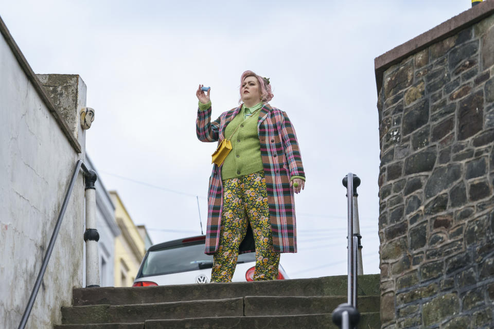 Ruby (Jayde Adams) stands at the top of some steps, looking pensive and holding her inhaler