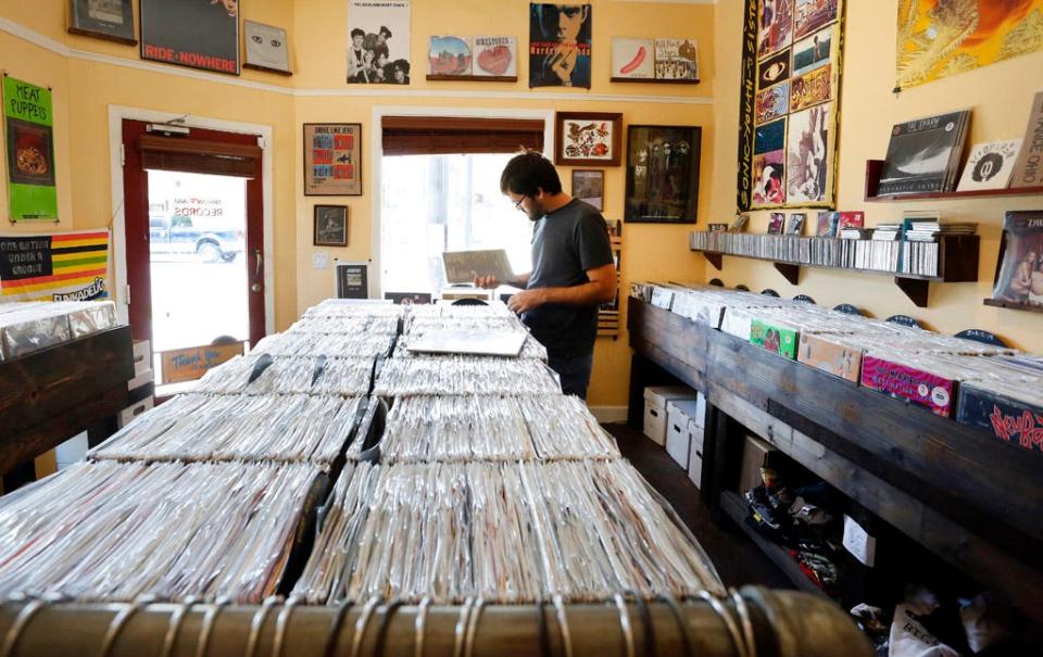 In this file photo, Ryan Williams sorts through vinyl records at Arrow's Aim Records old location on Sept. 9, 2013. Arrow's Aim owner Daniel Halal said the new shop, at 10 N. Main St. in the former F.L.A. Gallery, will provide him with 800 square feet of space, compared to the 275 square feet he worked with at 101 N. Main St.