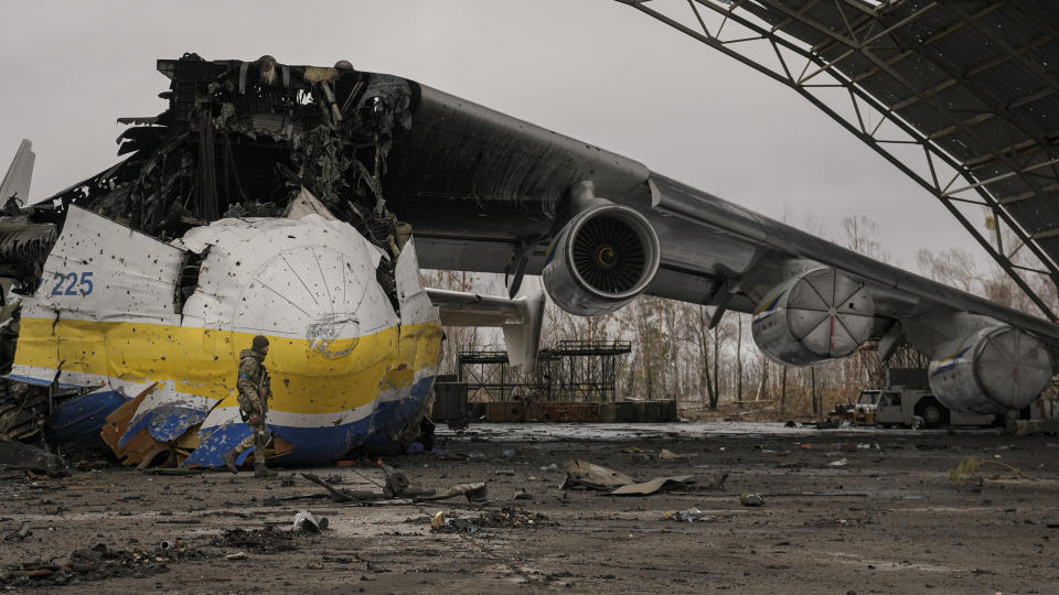 A Ukrainian serviceman walks by an Antonov An-225 Mriya aircraft destroyed during fighting between Russian and Ukrainian forces on the Antonov airport in Hostomel, Ukraine, Saturday, April 2, 2022. At the entrance to Antonov Airport in Hostomel Ukrainian troops manned their positions, a sign they are in full control of the runway that Russia tried to storm in the first days of the war. (AP Photo/Vadim Ghirda)