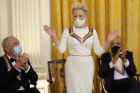 Bette Midler, joined by Lorne Michaels, left and Berry Gordy, right, stands for applause during the Kennedy Center Honorees Reception hosted by President Joe Biden and first lady Jill Biden at the White House in Washington, Sunday, Dec. 5, 2021. AP Photo/Carolyn Kaster)