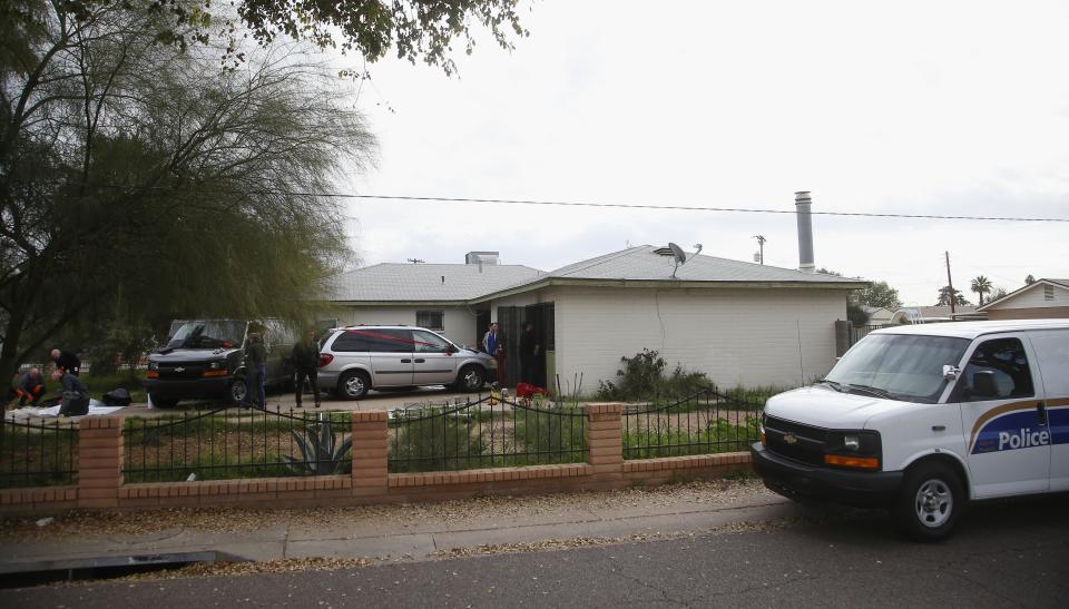 Police and fire investigators comb through a home where skeletal remains were found Wednesday, Jan. 29, 2020, in Phoenix. The remains have been found at a house where authorities previously removed at least one child as part of a child abuse investigation in which both parents of that child were in custody, police said Wednesday. (AP Photo/Ross D. Franklin)