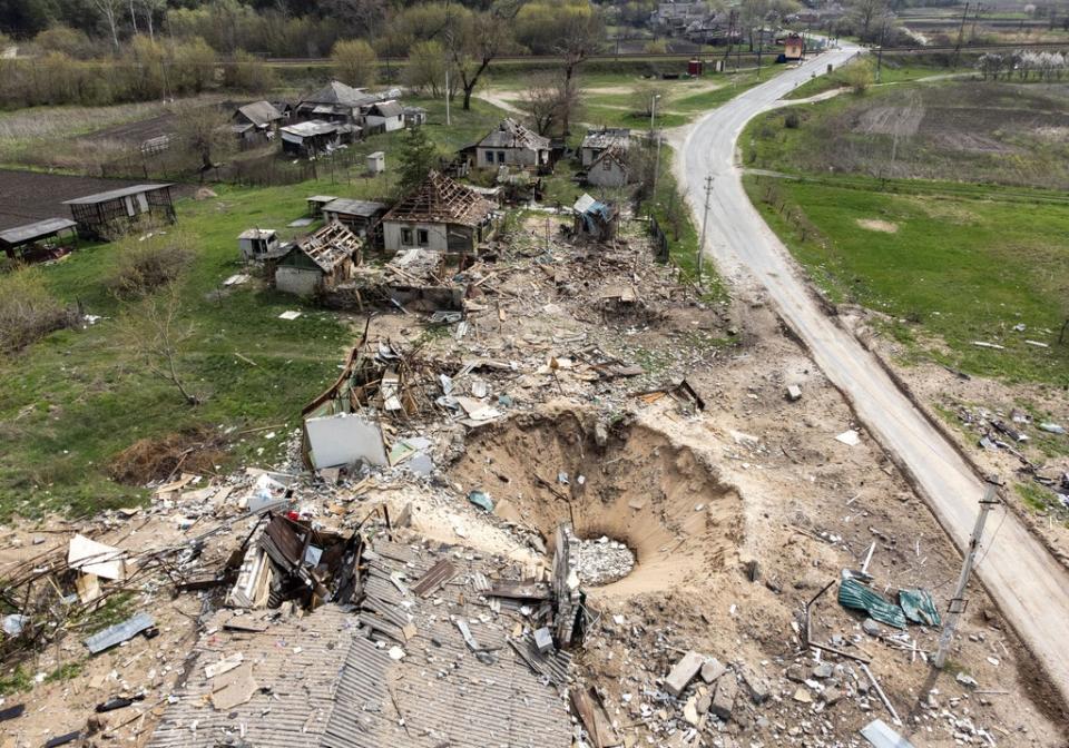 An aerial view shows a crater and destroyed homes in the village of Yatskivka, eastern Ukraine (AFP via Getty Images)