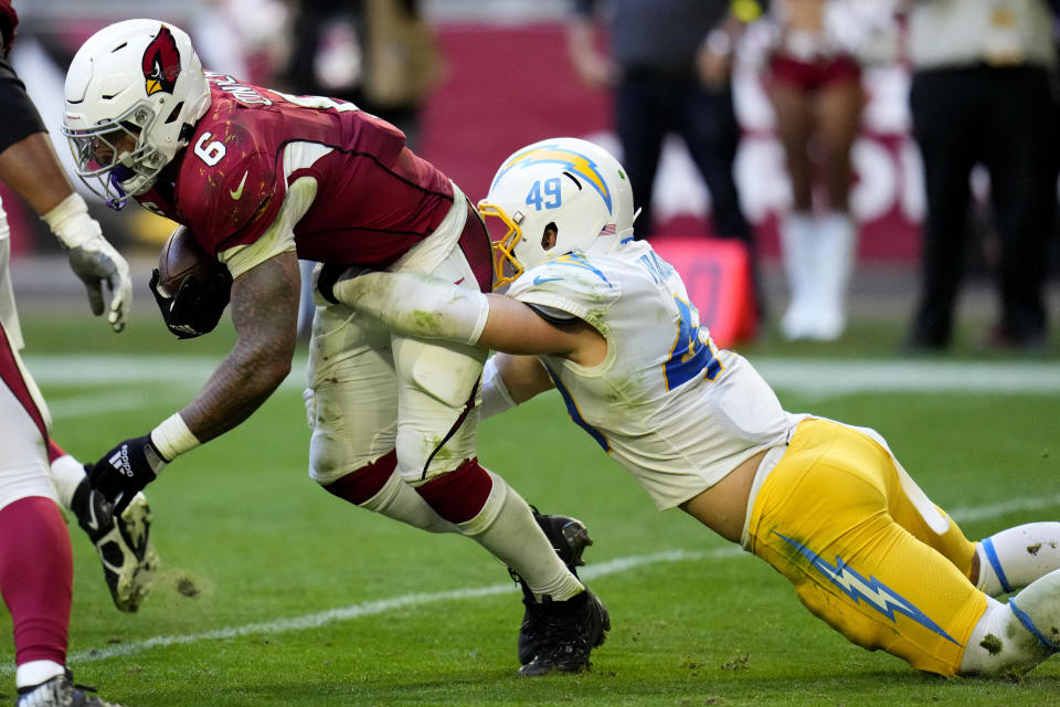 Los Angeles Chargers linebacker Drue Tranquill (49) tackles Arizona Cardinals running back James Conner (6) for a loss on the play during the second half of an NFL football game, Sunday, Nov. 27, 2022, in Glendale, Ariz. The Chargers defeated the Cardinals 25-24. (AP Photo/Ross D. Franklin)