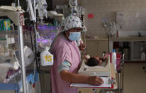 A nurse attends to a newborn baby in the intensive care unit of the Women's Hospital maternity ward in La Paz, Bolivia, Thursday, Aug. 13, 2020. Doctors say the supply of oxygen for the babies is becoming scarce, the result of nationwide blockades by supporters of the party of former President Evo Morales who object to the recent postponement of elections. Bolivia's political and social crisis is coinciding with the continued spread of the new coronavirus. (AP Photo/Juan Karita)