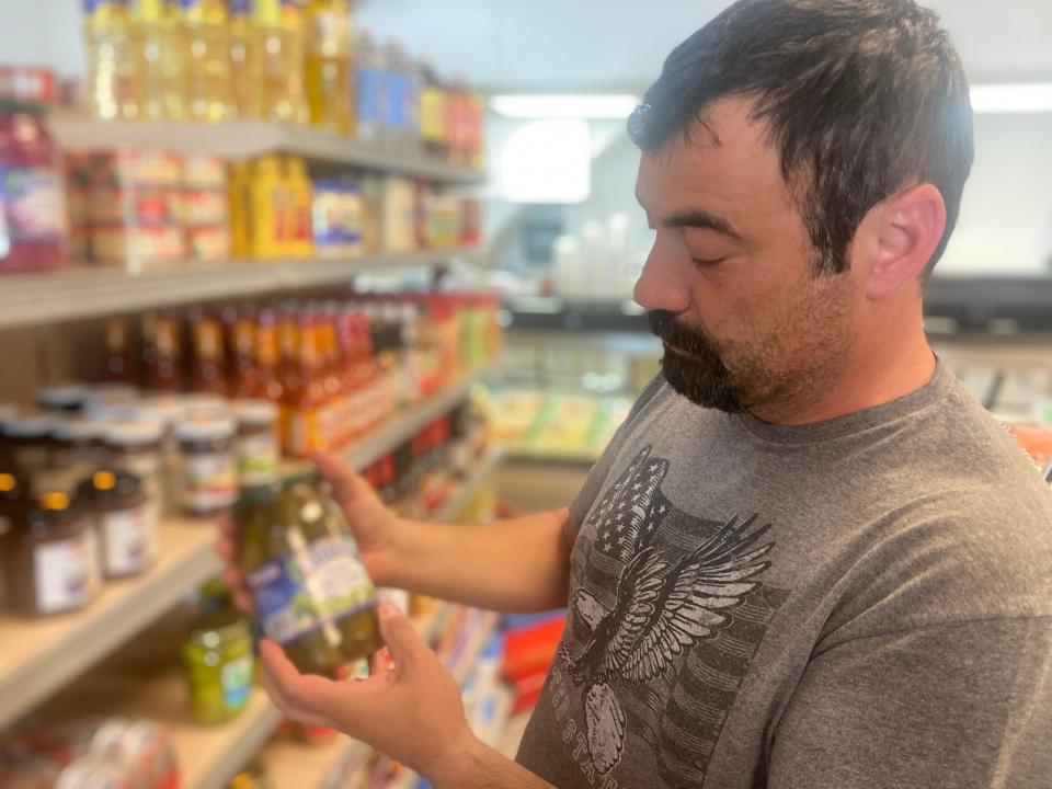 Adrian Pop, owner of Trawka's Market, at 1712 Payne Ave., shows off some of the European products he has stocked on his store shelves.