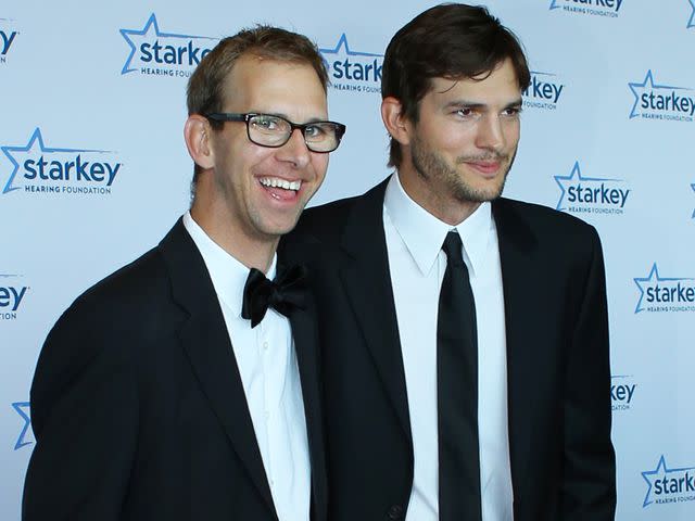 <p>Adam Bettcher/Getty</p> Michael Kutcher and brother Ashton Kutcher walk the red carpet before the 2013 Starkey Hearing Foundation's "So the World May Hear" Awards Gala on July 28, 2013.