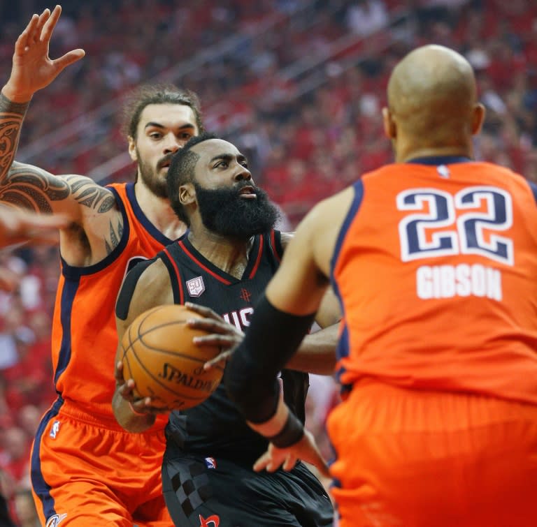 James Harden (C) of the Houston Rockets drives to the basket past the Oklahoma City Thunder players during the 2017 NBA playoffs' first round, in Houston, Texas, on April 16, 2017