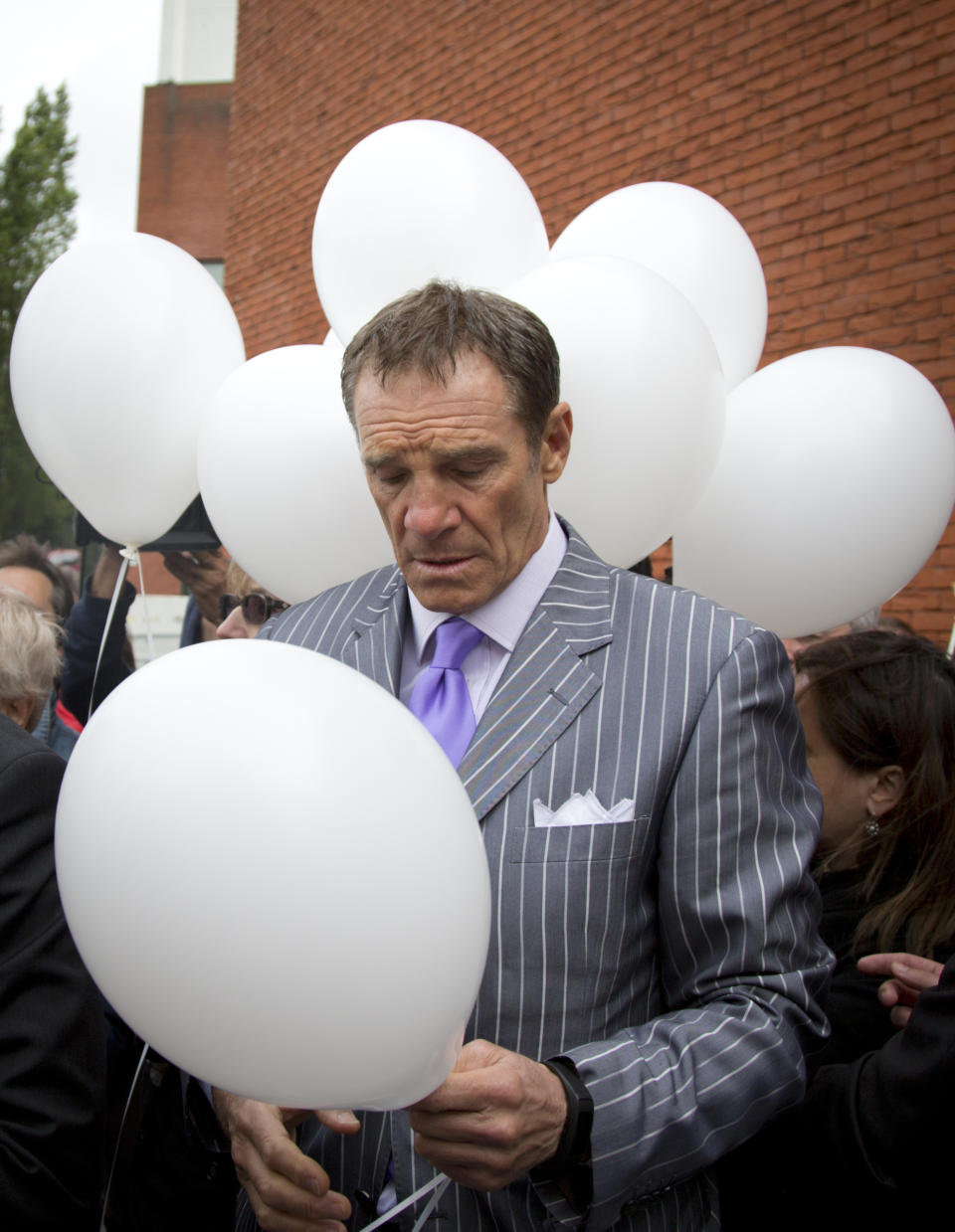 FILE - In this Friday, May 29, 2015 file photo, former Juventus player Sergio Brio looks down at a white balloon before releasing it during a commemoration at the King Boudouin (formerly the Heysel) Stadium in Brussels. Friday, May 29, 2020 marks 35 years since 39 victims lost their lives during a European Cup football match between Liverpool and Juventus due to a surge of rival supporters resulting in a collapsed wall. (AP Photo/Virginia Mayo, File)