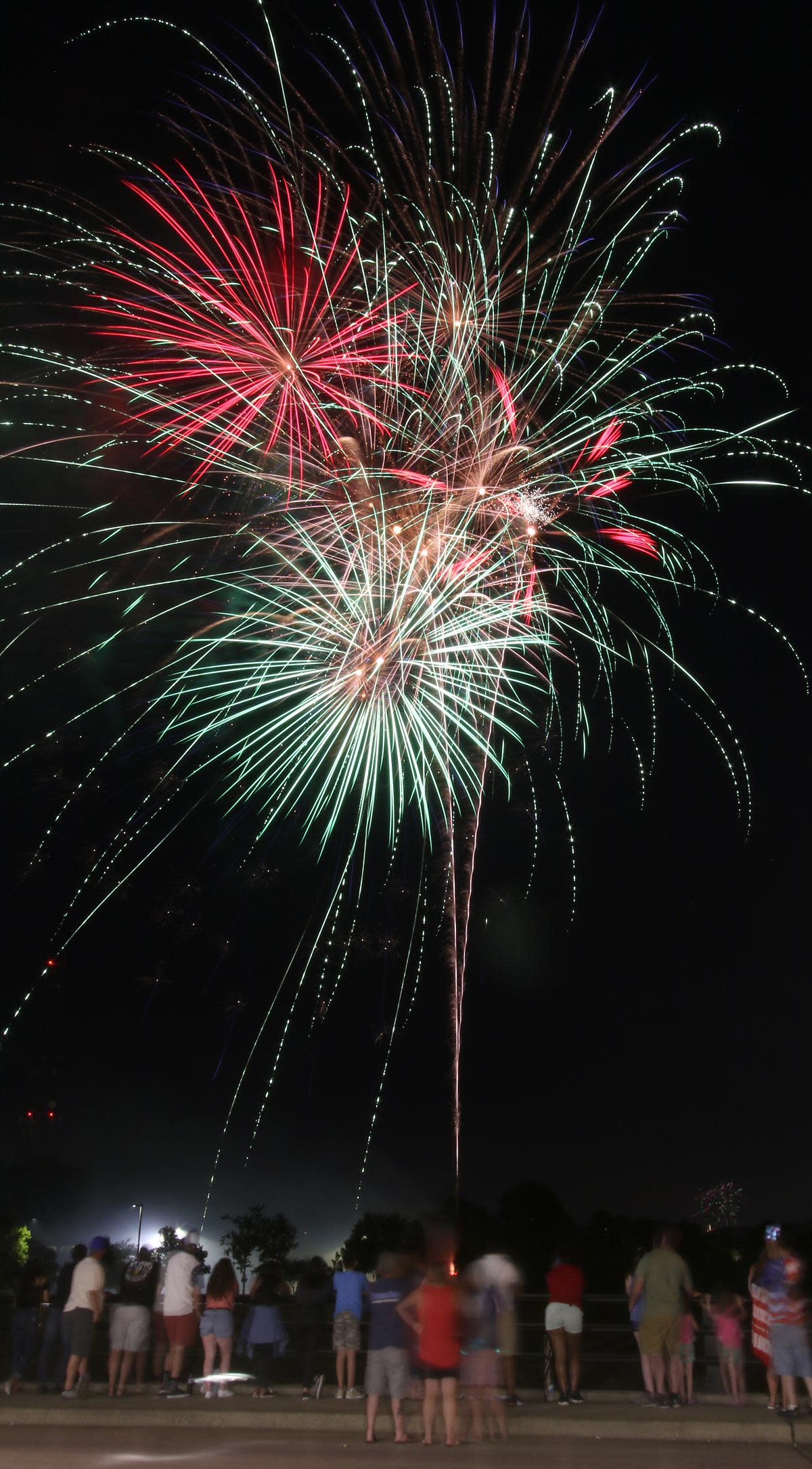 People line the Martin Luther King, Jr. Drive bridge to watch fireworks during the City of Gastonia's Fourth of July Celebration held at the Rotary Centennial Pavilion Thursday evening, July 4, 2019.