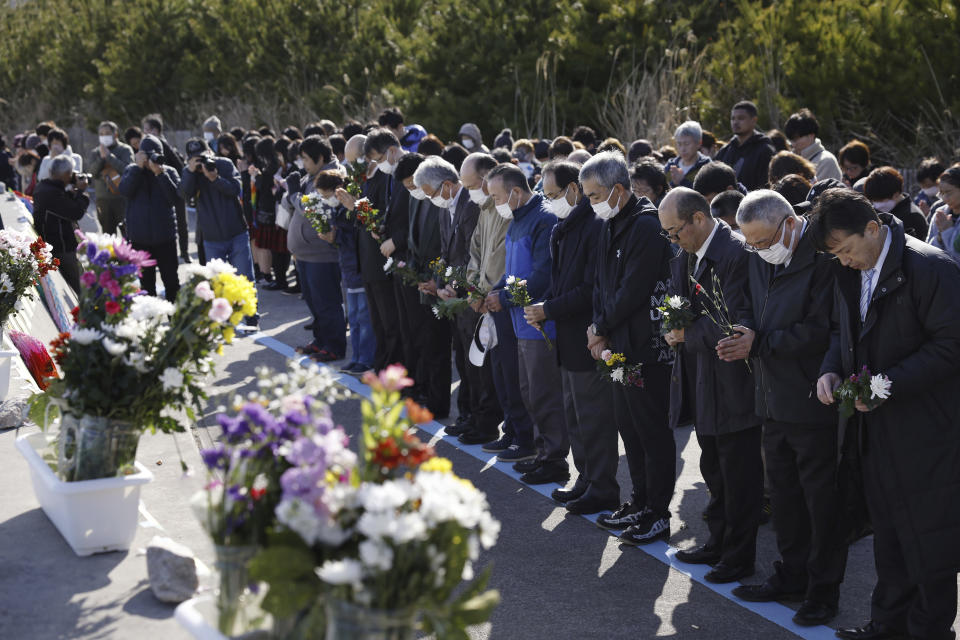 People observe a moment of silence at 2:46 p.m., the moment the earthquake struck in Iwaki, Fukushima prefecture, northern Japan Monday, March 11, 2024. Japan marked the 13th anniversary of the massive earthquake, tsunami and nuclear disaster. (Kyodo News via AP)