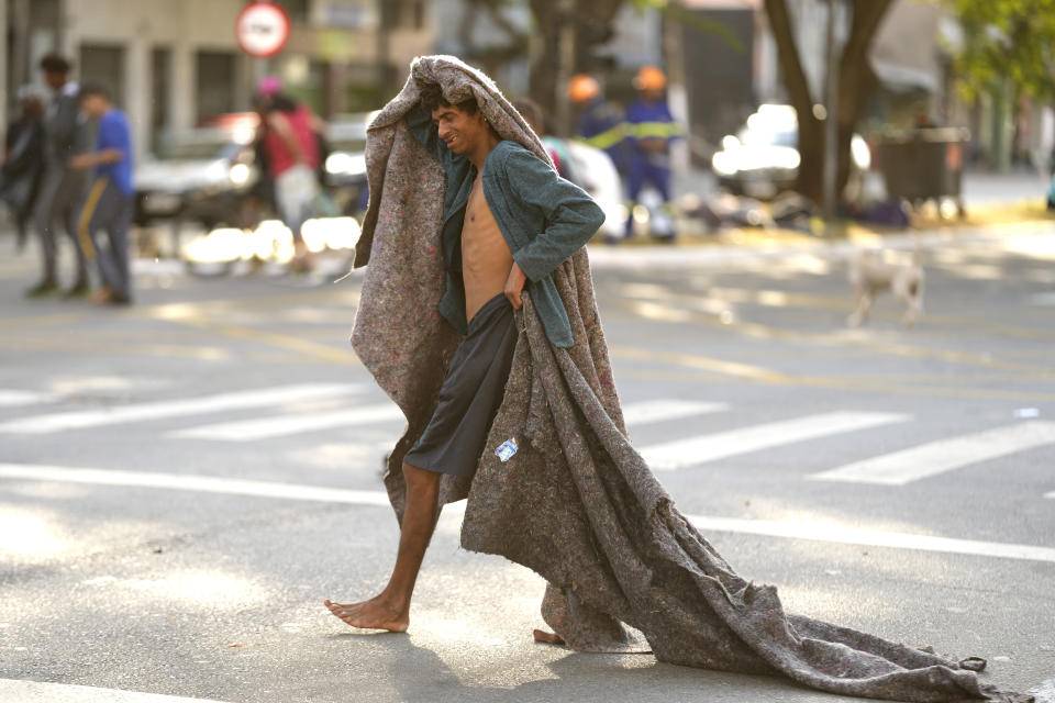 FILE - A homeless man crosses a street in an area occupied by drug users known as Crackland, in downtown Sao Paulo, Brazil, May 11, 2023. The decline of Sao Paulo's downtown area has accelerated over the last year, where crack users seem to be everywhere, roaming the central streets of South America's biggest city. (AP Photo/Andre Penner, File)