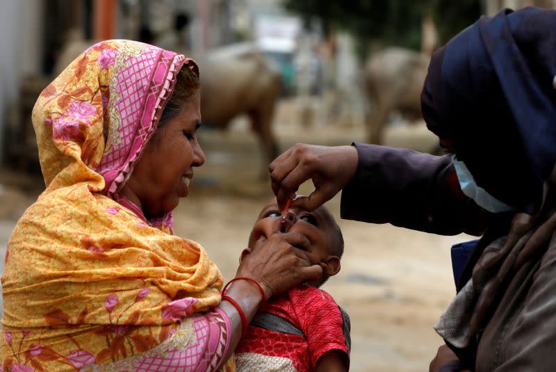 A boy receives polio vaccine drops, during an anti-polio campaign, in a low-income neighborhood, in Karachi,