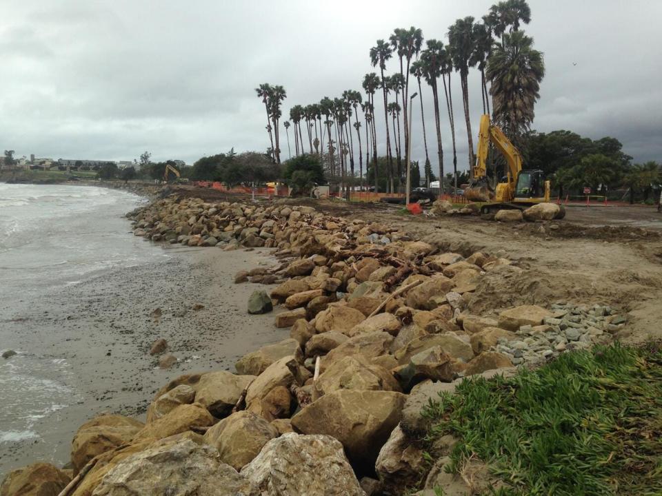 Installing large boulders as rip rap to armor the shore against further erosion at Goleta Beach in Southern California. The tide is very low (negative).