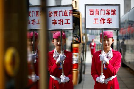 An usher holds a sign for a hotel for delegates returning from morning sessions on the second day of the 19th National Congress of the Communist Party of China the Great Hall of the People in Beijing, October 19, 2017. REUTERS/Thomas Peter