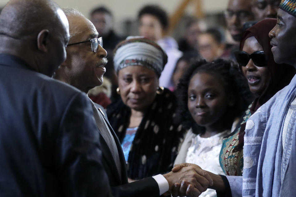 The Rev. Al Sharpton, second from left, civil rights activist and founder of the National Action Network, shakes hands with Imam Al Hassan Kamagtey, of Yonkers, N.Y., right, as Omo Muhammed, second from right, mother of 19-year-old fatal shooting victim Mubarak Soulemane, looks on, Sunday, Jan. 26, 2020, during ceremonies to honor Soulemane's life, at the First Calvary Baptist Church, in New Haven, Conn. The Jan. 15, 2020 shooting by a Connecticut State Police trooper took Soulemane's life following a high-speed car chase, in West Haven, Conn. (AP Photo/Steven Senne)