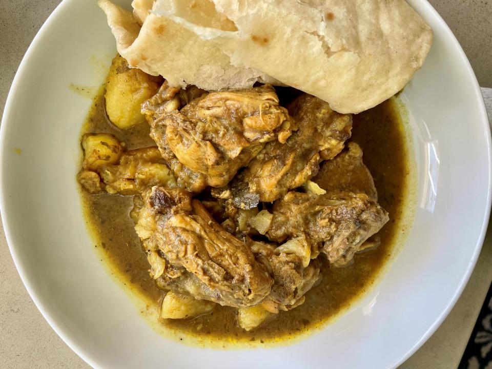 The chicken curry from Dru's West-Indian Roti Shop is best eaten with a side of Dru's fluffy roti to balance its delicious kick of spice.