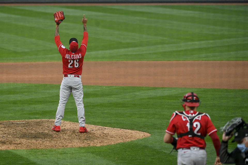 Cincinnati Reds pitcher Raisel Iglesias, left, reacts after striking out Minnesota Twins' Ehire Adrianza and winning a baseball game during the tenth inning Sunday, Sept. 27, 2020, in Minneapolis. (AP Photo/Craig Lassig)