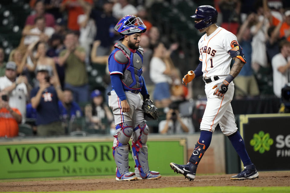 Houston Astros' Carlos Correa (1) scores after hitting a home run as Texas Rangers catcher Jose Trevino looks on during the ninth inning of a baseball game Tuesday, June 15, 2021, in Houston. (AP Photo/David J. Phillip)